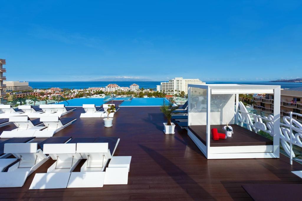 美洲海滩Tigotan Lovers & Friends Playa de las Americas - Adults Only (+18)的阳台配有白色椅子,享有海景。