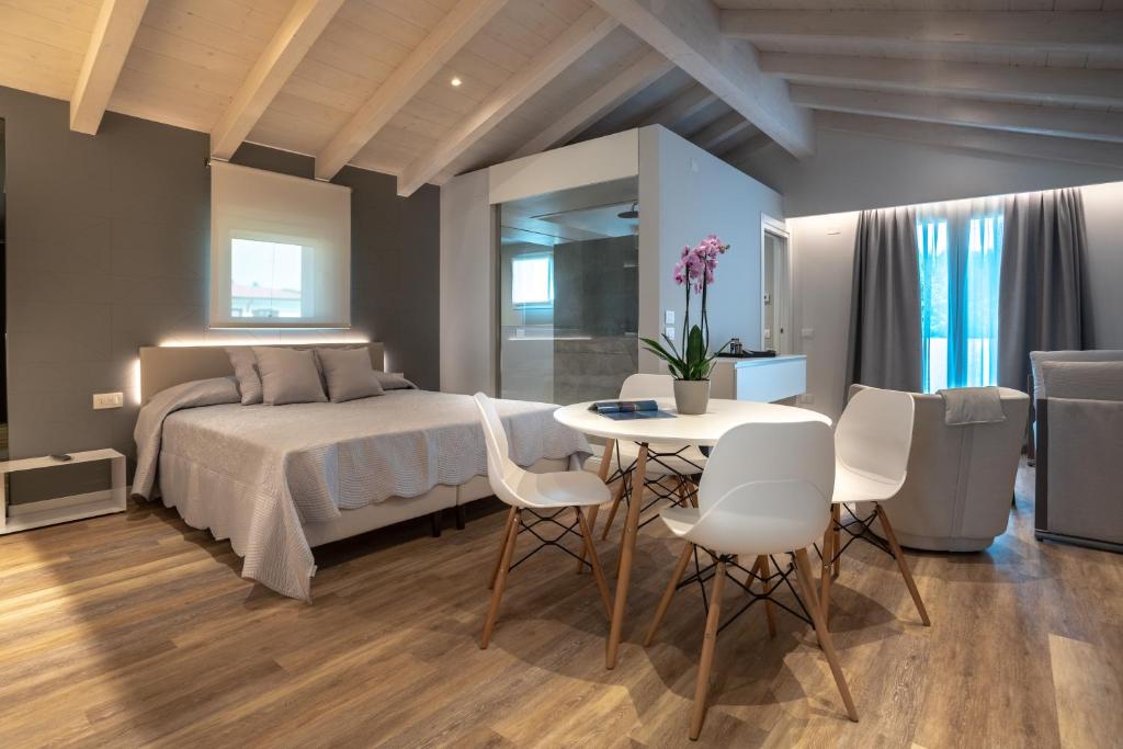 代森扎诺-德尔加达Viola Relais的卧室配有一张床和一张桌子及椅子