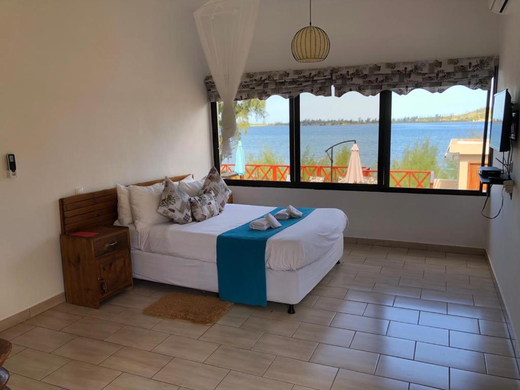 普拉伊拉多比莱尼Villa Espanhola Bilene的一间卧室配有一张床,享有水景