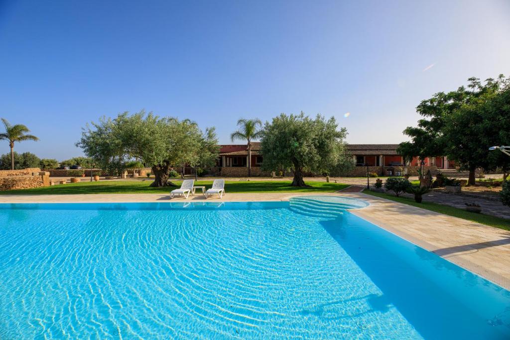 阿雷内拉Agriturismo Masseria Sant' Elia的一个带两把椅子的游泳池以及一座房子