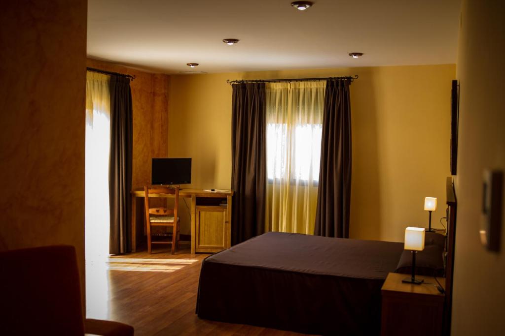 DeifontesHostal Rural el Nacimiento的一间卧室配有一张床和一张书桌