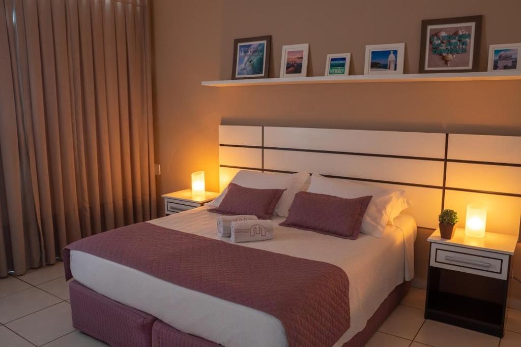 卡波布里奥马列酒店的一间卧室配有一张大床,两盏灯