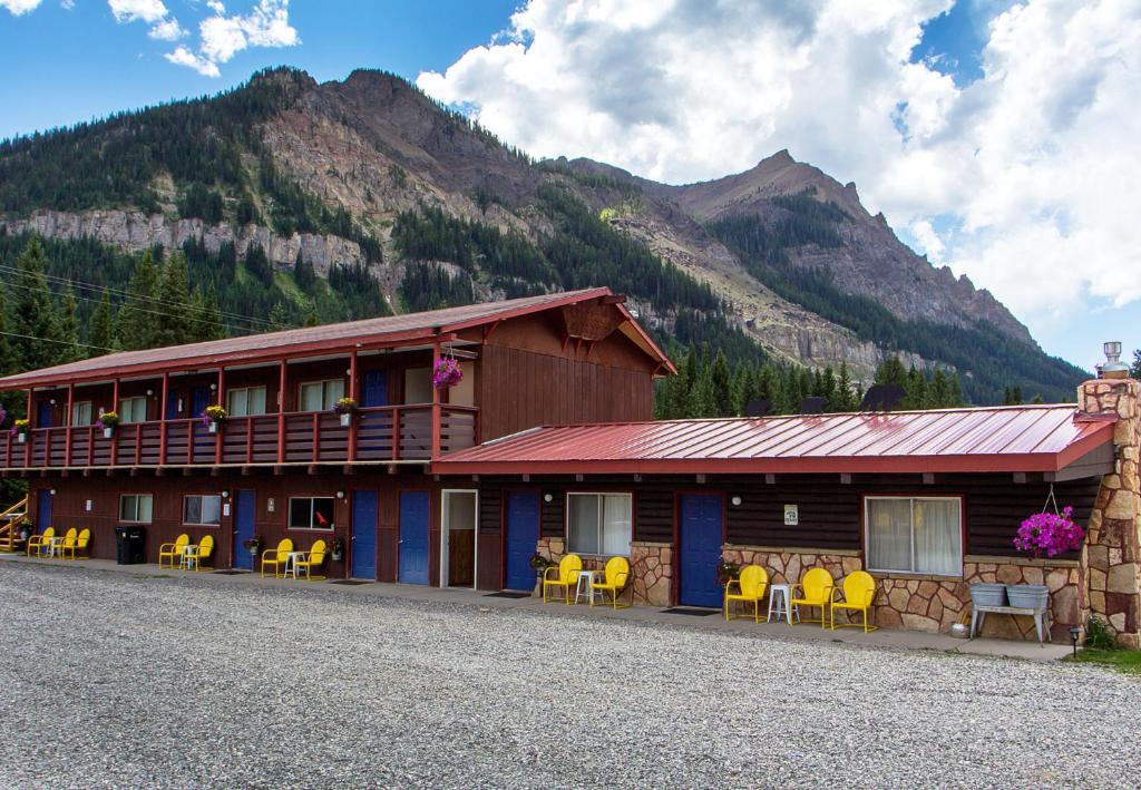 库克市High Country Motel and Cabins的山前有黄色椅子的建筑