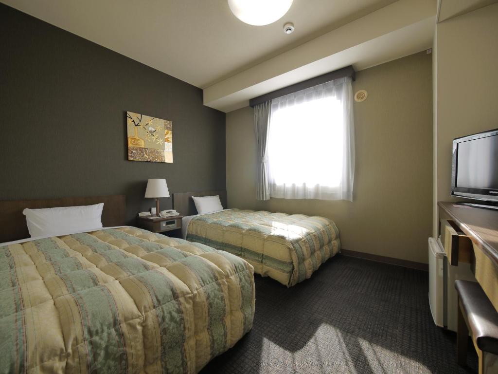 各务原市各务原路线经济型酒店的酒店客房设有两张床和电视。