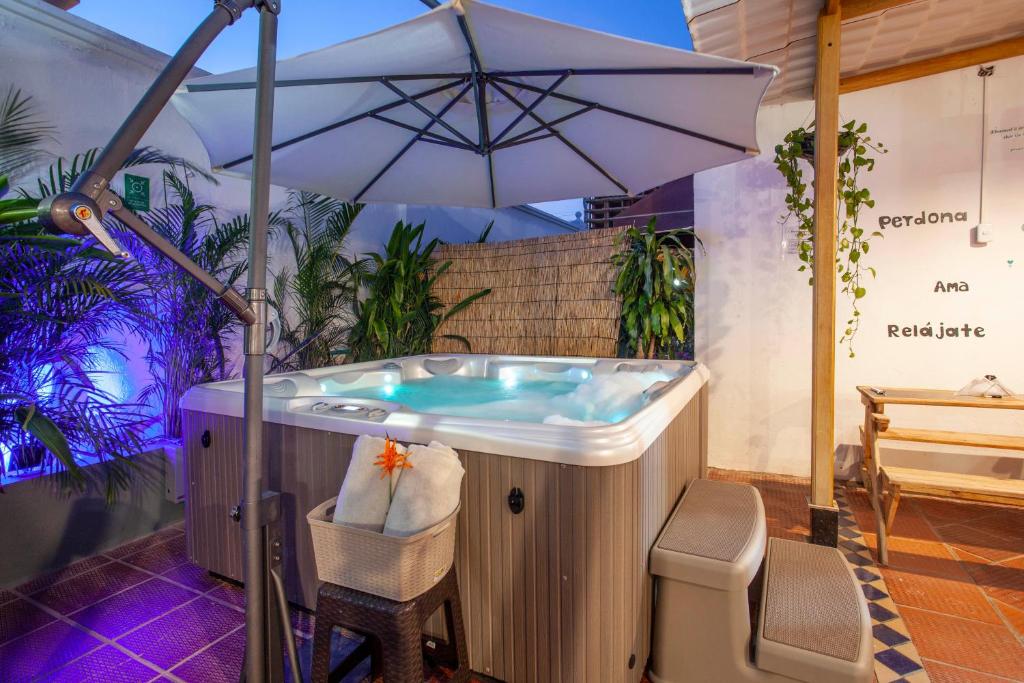 卡塔赫纳Mucura Hotel & Spa的庭院内带遮阳伞的热水浴池