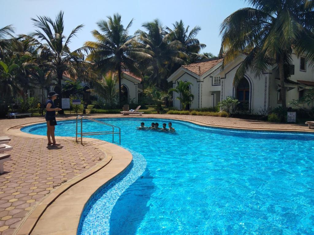 巴加Casa Legend Villa & Apartments Arpora - Baga - Goa的站在游泳池前的人
