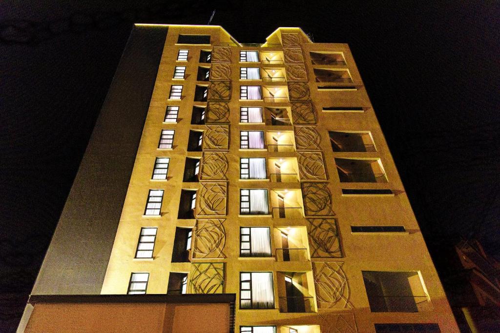 内罗毕L'Aziz Suites的一座高大的建筑,晚上有灯
