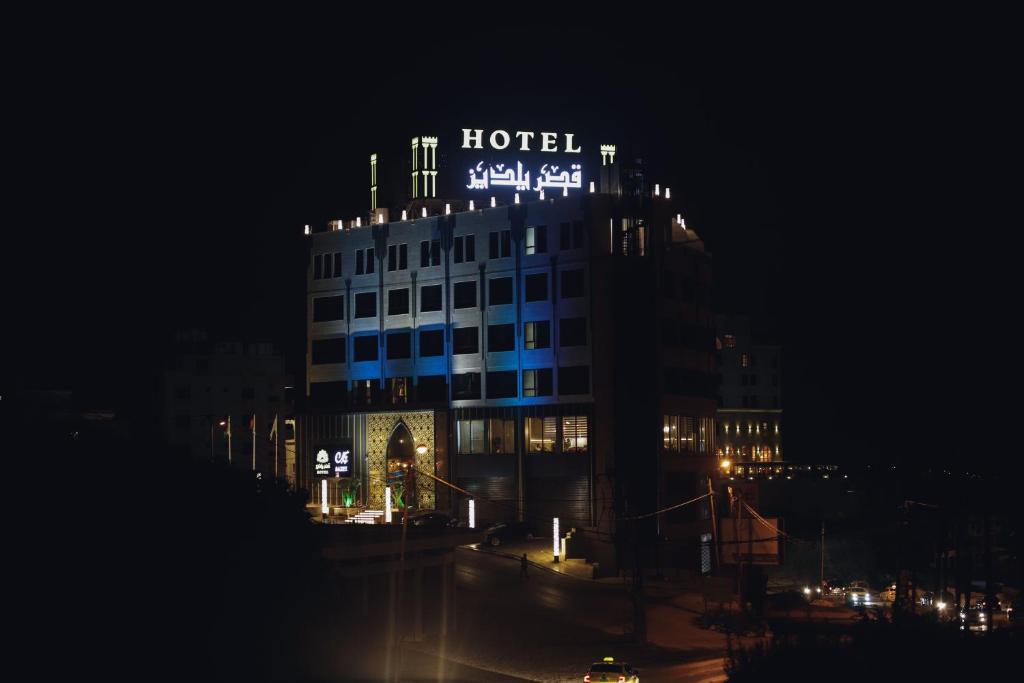 纳布卢斯Yaldiz Palace Hotel的一家晚上在上面标有标志的酒店