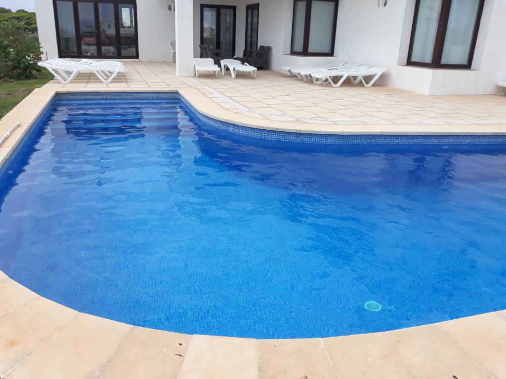卡拉莫若尔Villa Elegante的一座大型蓝色游泳池,位于房子旁边