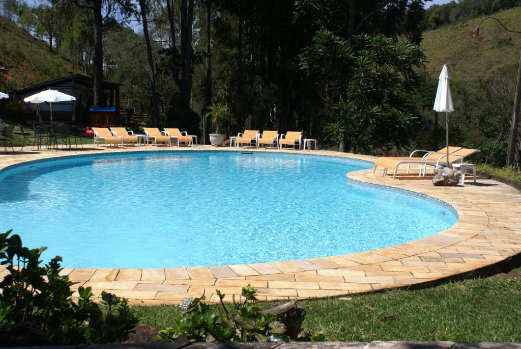 库尼亚Hotel Fazenda São Francisco的一个带椅子和桌子的大型游泳池