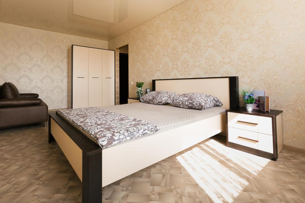 苏梅Luxury apart-hotel on Kharkovskaya neer Manufaktura的一间卧室配有一张大床和一把椅子