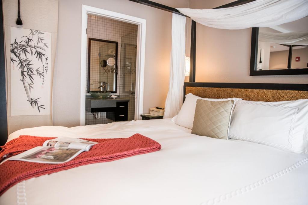 迈阿密海滩卡德特酒店的卧室配有一张白色的床,上面有书