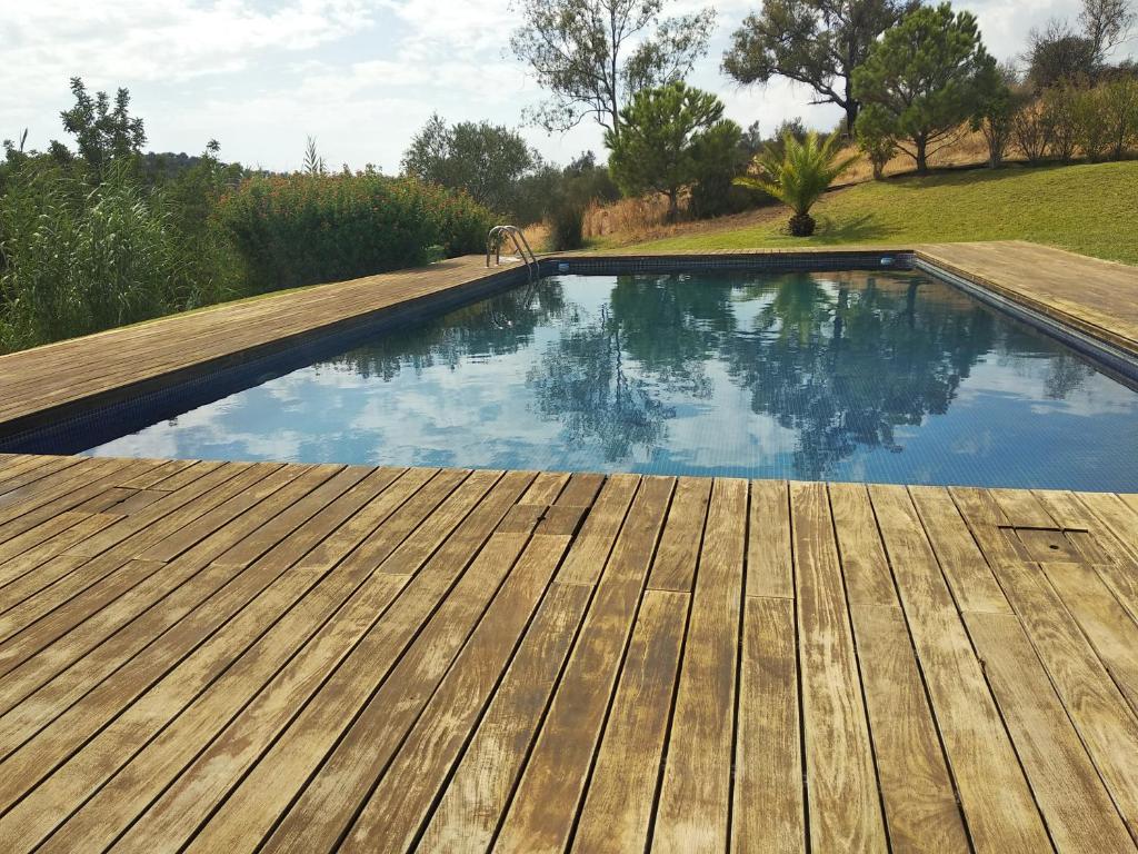 塔维拉Casa da Osga的一个带木甲板和蓝色海水的游泳池