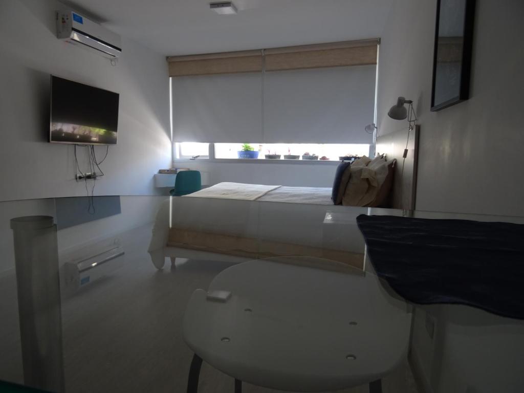 布宜诺斯艾利斯Recoleta Departamento的一间卧室配有一张床、一张桌子和一台电视。