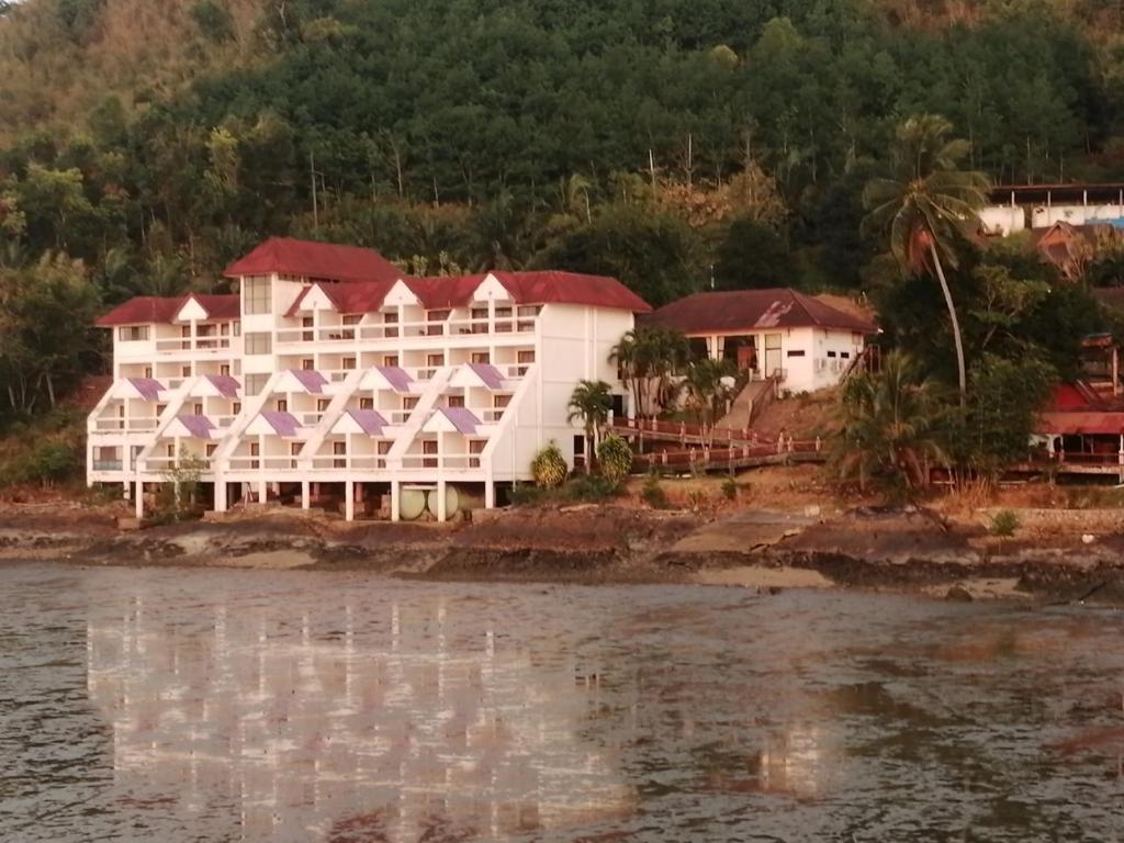 拉廊Jansom Beach Resort的水边的白色大建筑