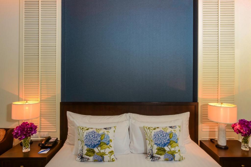 曼谷The Rose Residence, Bangkok的一间卧室配有一张带两盏灯和两个枕头的床。
