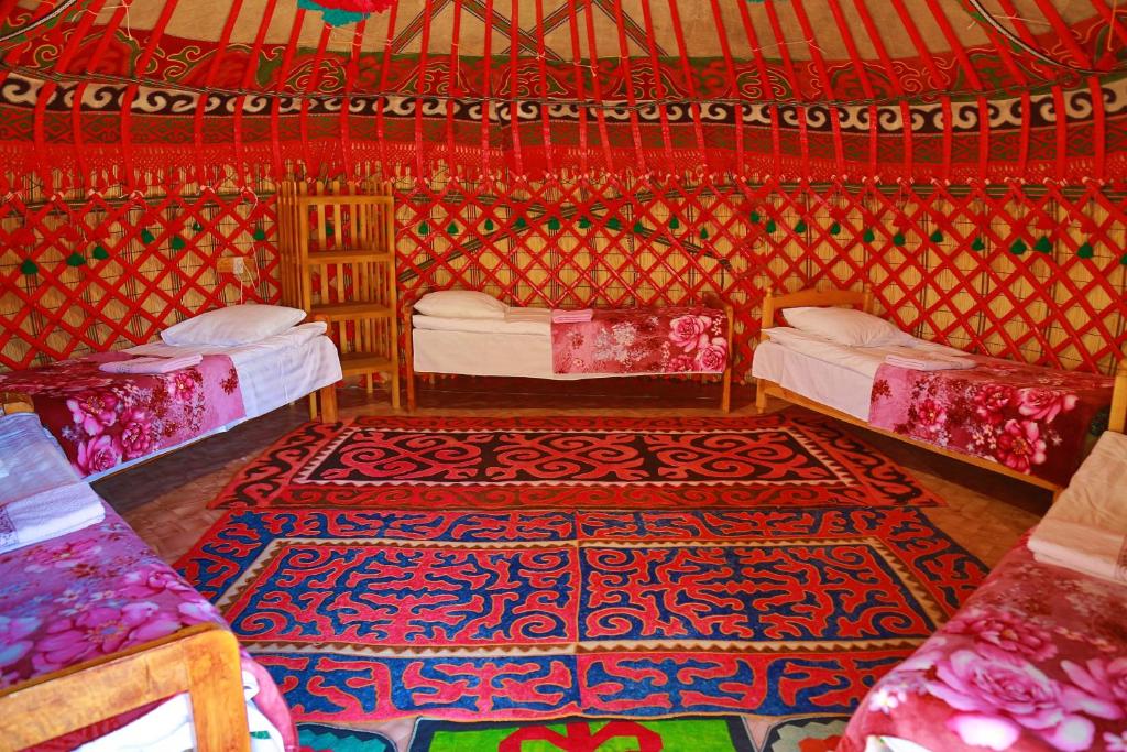 卡拉科尔Happy Nomads Yurt Camp & Hostel的一间设有两张床的房间和一张地毯