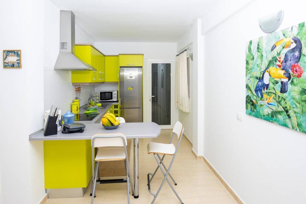 阿格特Elisabeth Apartment, peace and relax in Agaete的厨房配有黄色橱柜和桌椅