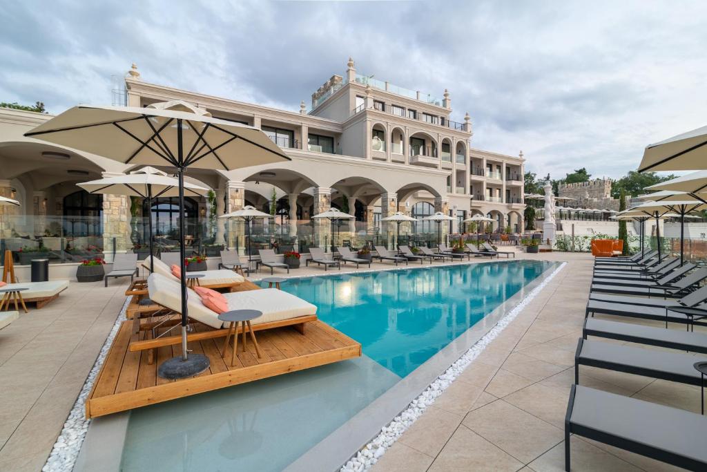 圣君士坦丁和海伦那Villa Chinka by Astor Garden Hotel - Adults Only的游泳池,带椅子和遮阳伞