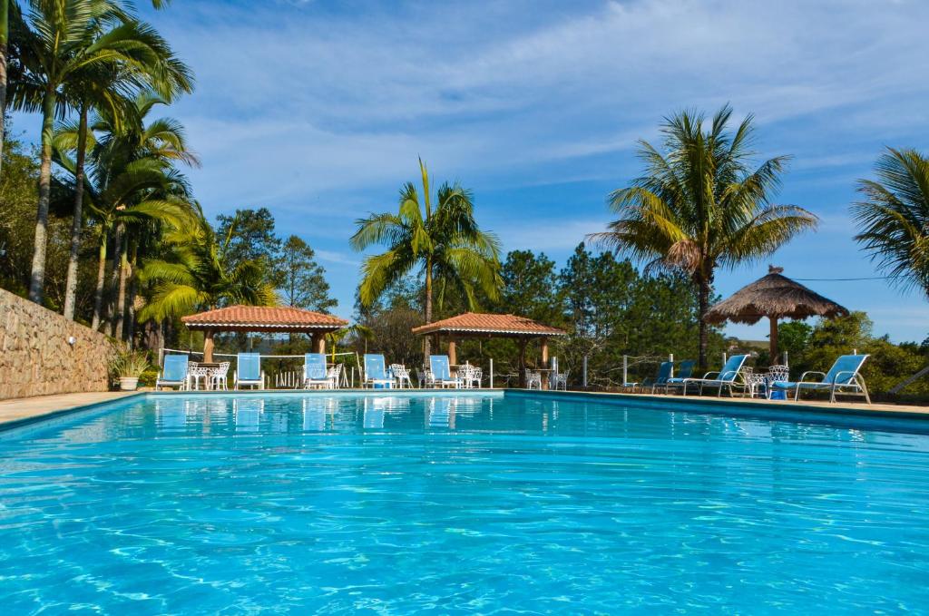 纳扎雷保利斯塔加利西亚庄园别墅酒店的一个带椅子的游泳池,棕榈树