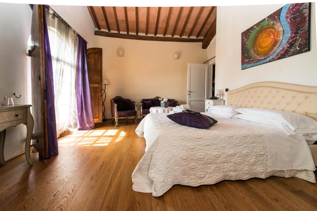 丘西拉尔波罗迪加姆里酒店的卧室配有一张白色的大床,铺有木地板