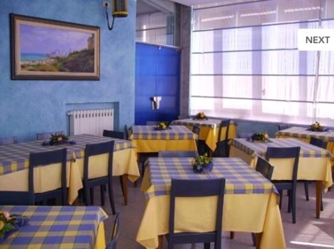 泰尔莫利Pensione Villa Ida的餐厅设有黄色和蓝色的桌椅