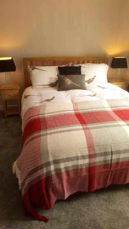 爱丁堡Haddington George House的一间卧室配有一张带红白毯子的床