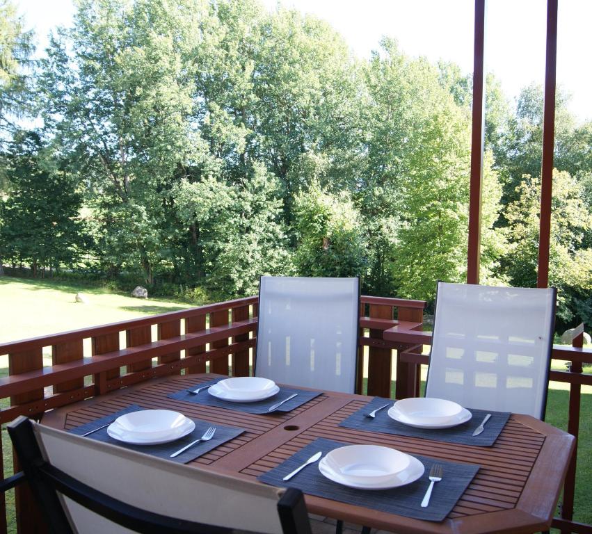 施卢赫湖Ferienwohnung Schwarzwaldlust的门廊上配有带白色板子和椅子的木桌