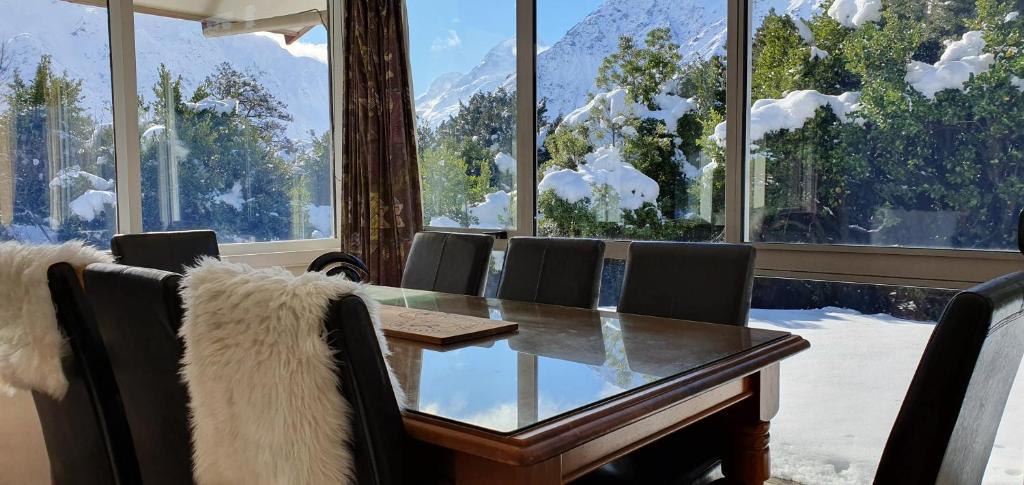 库克山村Aoraki Alpine Chalet的一间带桌椅和窗户的用餐室