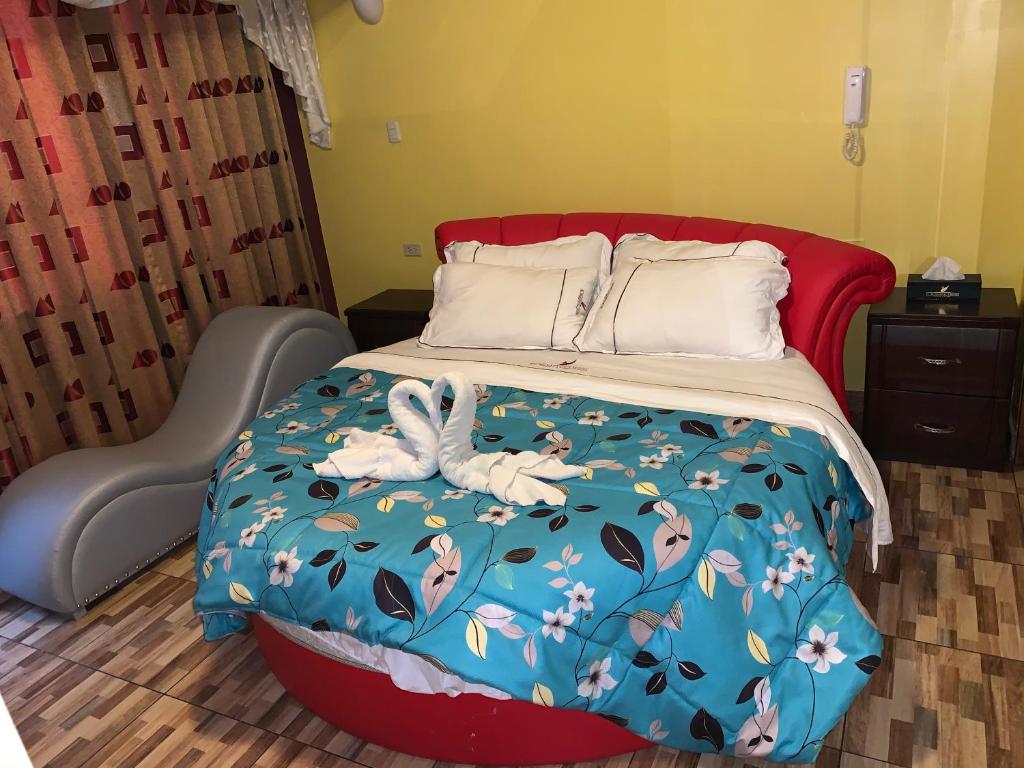 利马Hotel Manantial No,001的一张带蓝色棉被的床,上面有两只天鹅
