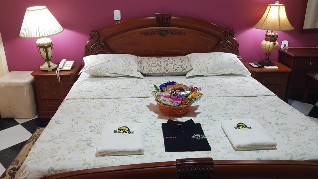 塔巴廷加塔卡纳酒店的一张带两张餐巾和一篮鲜花的床