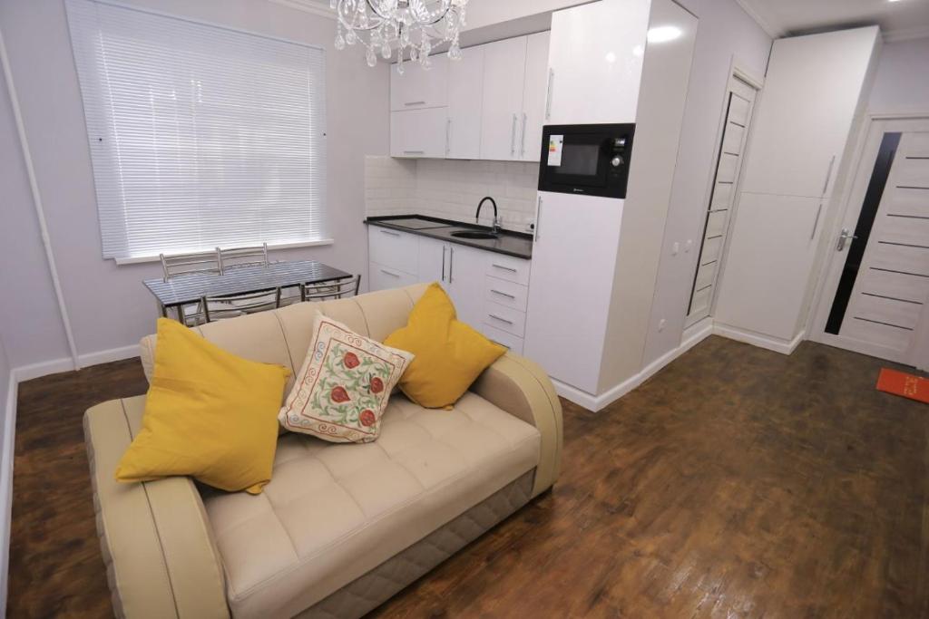 撒马尔罕Luxury 2 bedrooms apartment walking distance from Gur-Emir的厨房里配有带黄色枕头的白色沙发