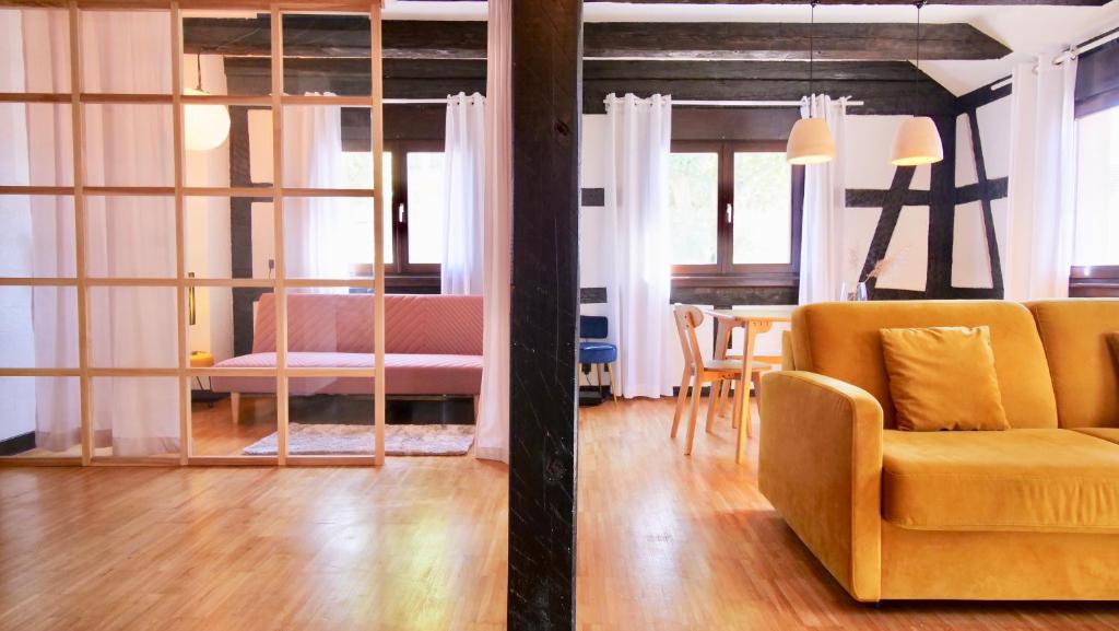 希尔蒂盖姆Bonheur的一间带黄色沙发的客厅和一间用餐室