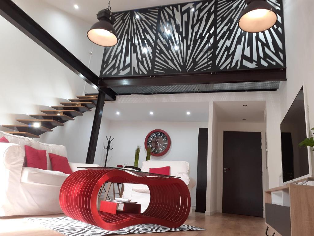 卡斯特尔" Les Lofts de Mérigonde "的一间带红色沙发和楼梯的客厅