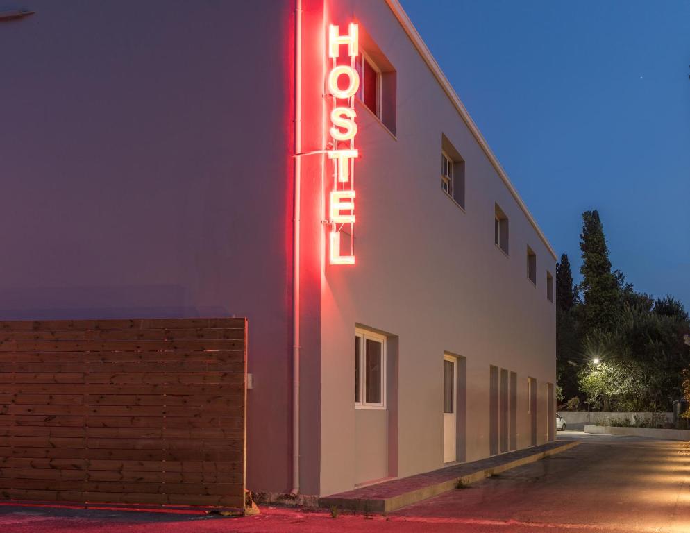 科孚镇Local Hostel & Suites的建筑物一侧的 ⁇ 虹灯标志