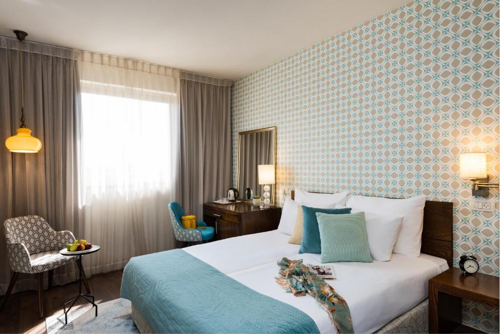 耶路撒冷普瑞玛罗亚尔绸酒店的配有一张床、一张书桌和一扇窗户的酒店客房