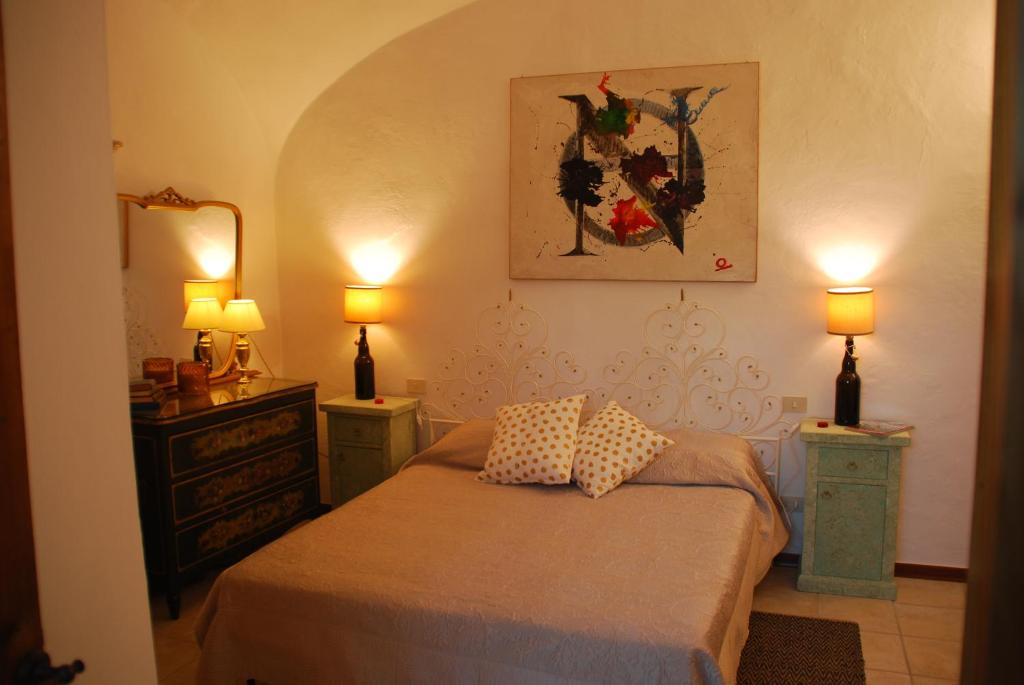 圣吉米纳诺Orto di Emma的一间卧室配有一张带2个床头柜和2盏灯的床。
