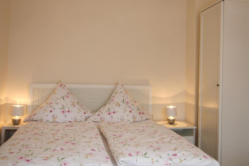 巴特尚道Ferienwohnung Zum Lilienstein的一张带粉色和白色床单及枕头的床