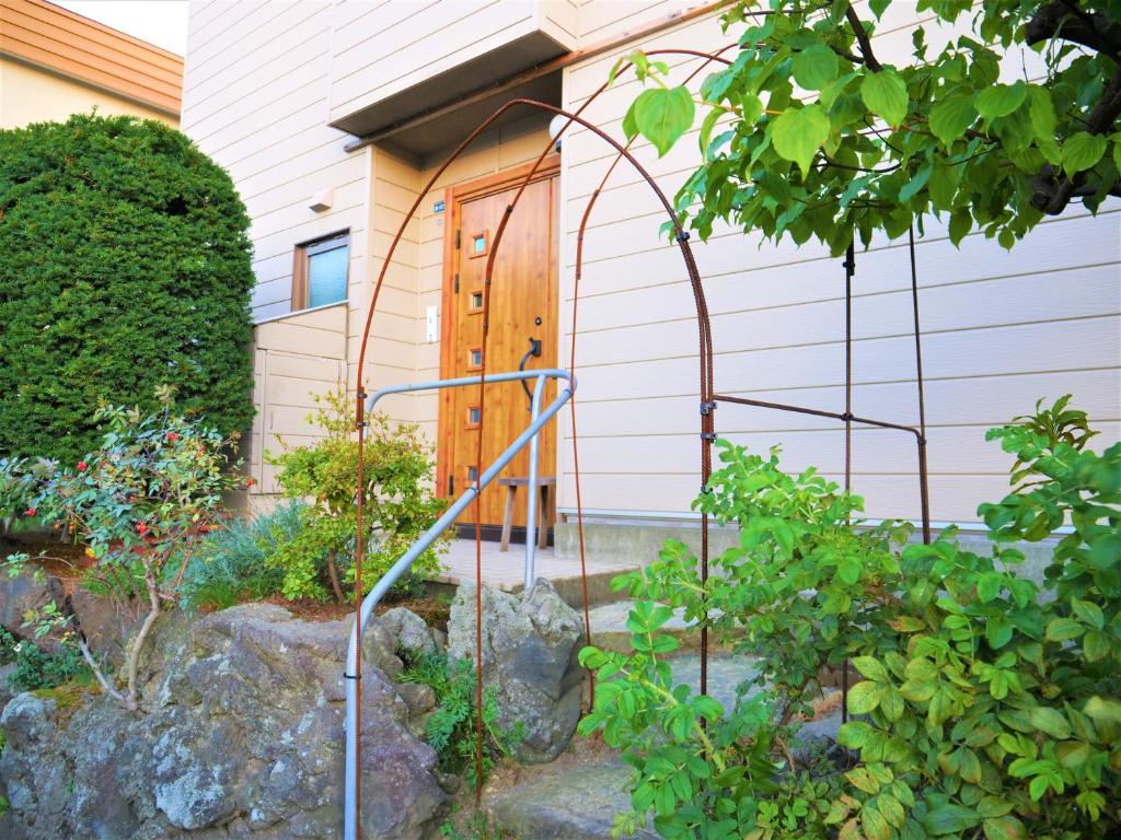 札幌Minpaku Mon的房屋前设有带秋千的花园