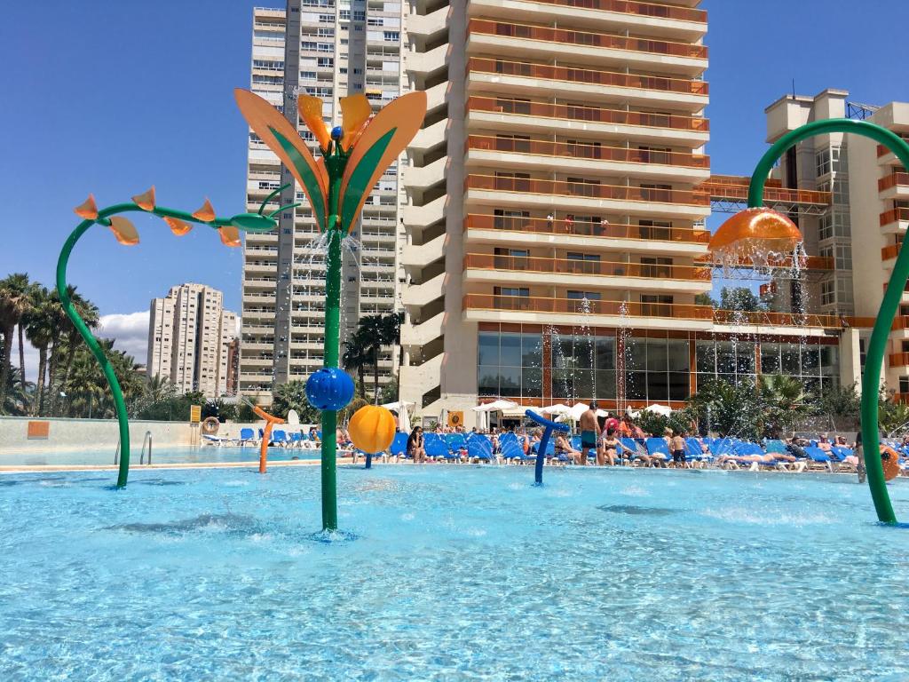 贝尼多姆Hotel & SPA Dynastic的游泳池里有一个蓝色的海水和绿杆