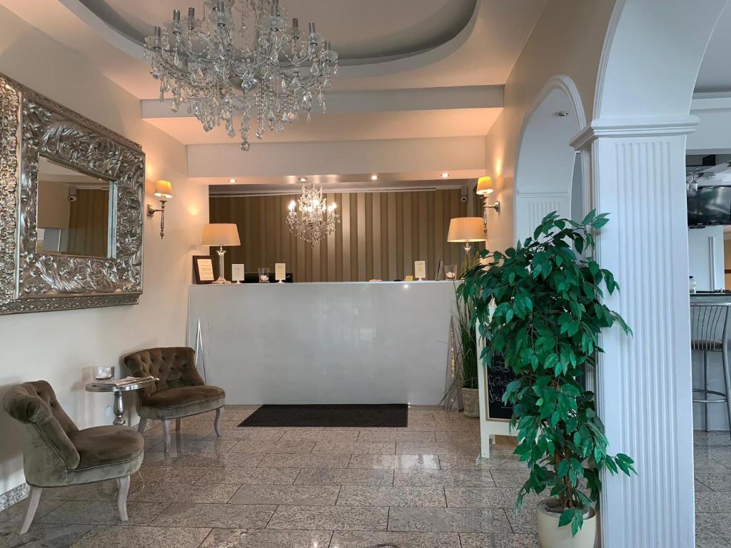 代尔门霍斯特布莱梅里德尔酒店的大堂设有椅子、吊灯和植物