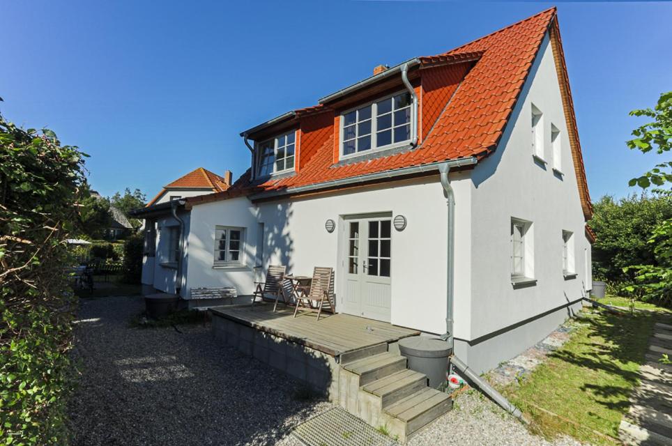 克洛斯特Hügelhus的白色的房子,有橙色的屋顶和甲板