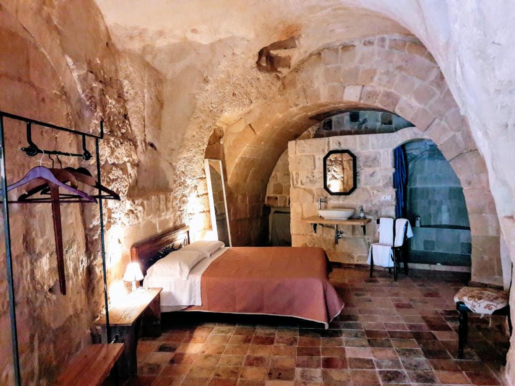 马泰拉Cave Rooms Sassi的石头间内一间卧室,配有一张床