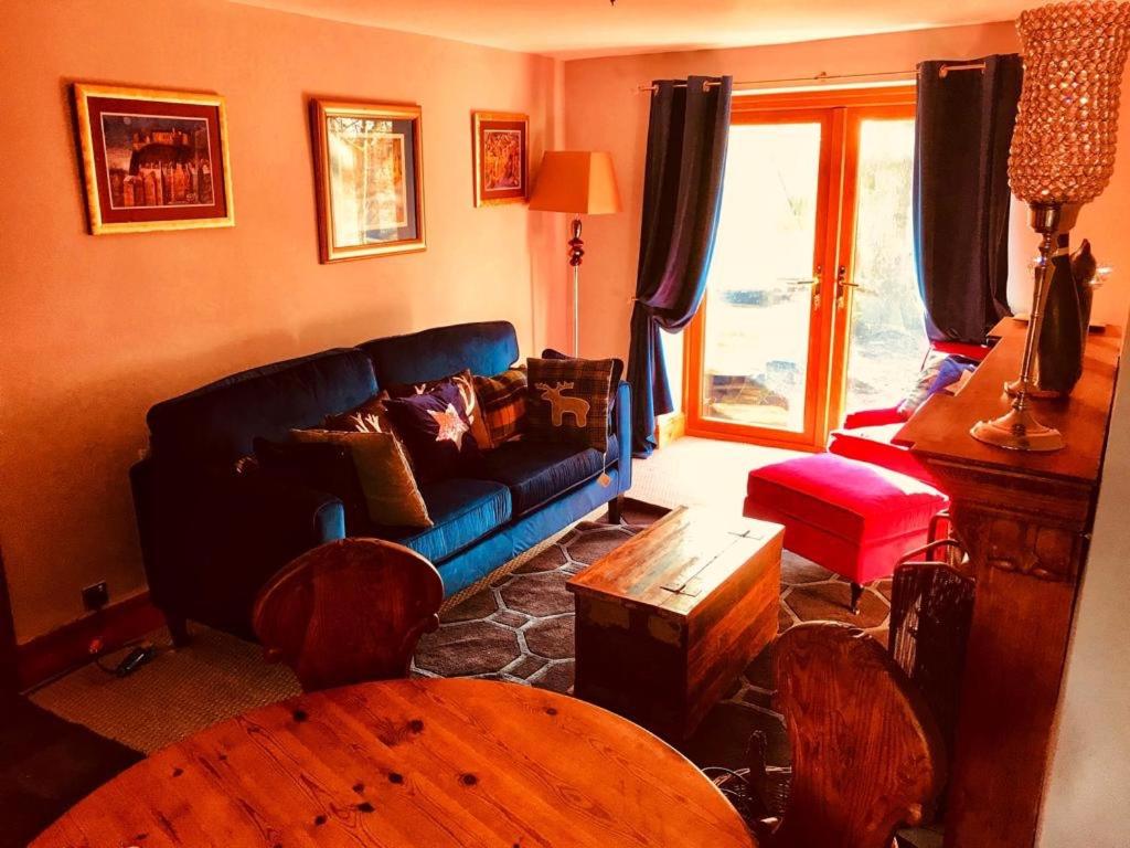 萨德尔沃思The Cottage, Grotton Hall, Lydgate, Saddleworth的客厅配有蓝色的沙发和桌子