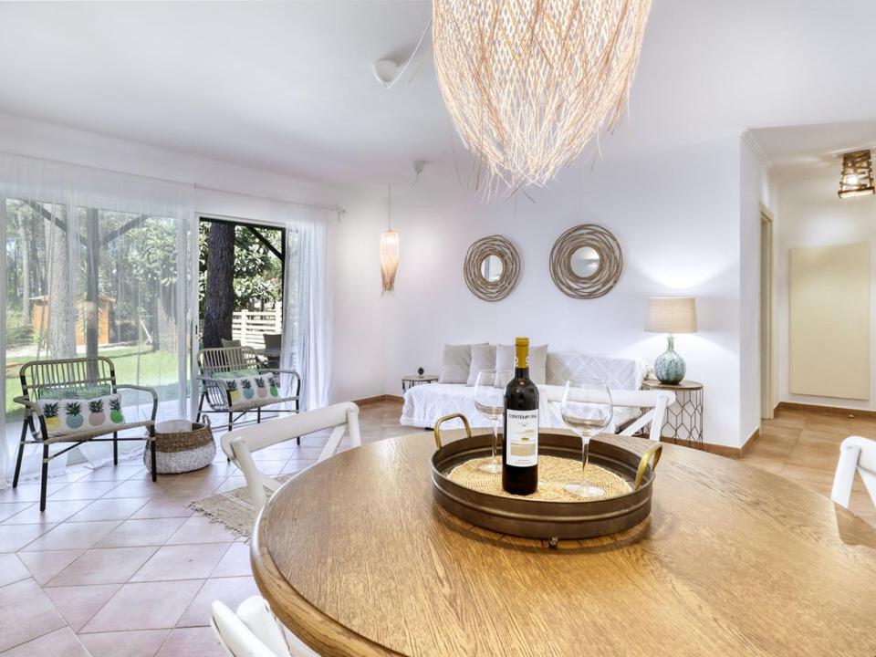 CarcereiroAroeira Golf - Beach House的客厅配有带一瓶葡萄酒的桌子