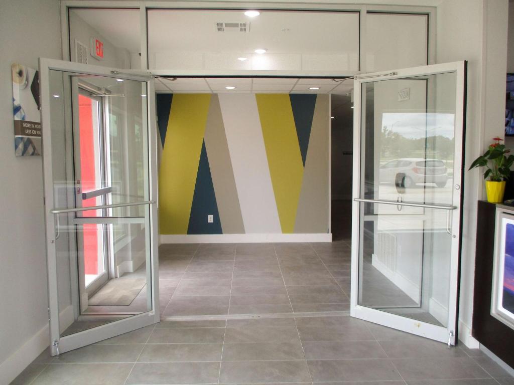 艾伦港Studio 6-Port Allen, LA - Baton Rouge I-10的两扇玻璃门,位于一间多彩的房间里