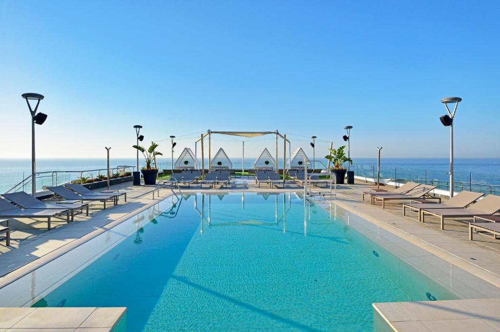 多列毛利诺斯太阳海岸美利亚酒店的一个带椅子的游泳池,背景是大海
