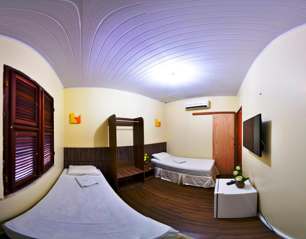 MaracanaúPousada das Maracanãs的一间设有两张床和一台电视的房间
