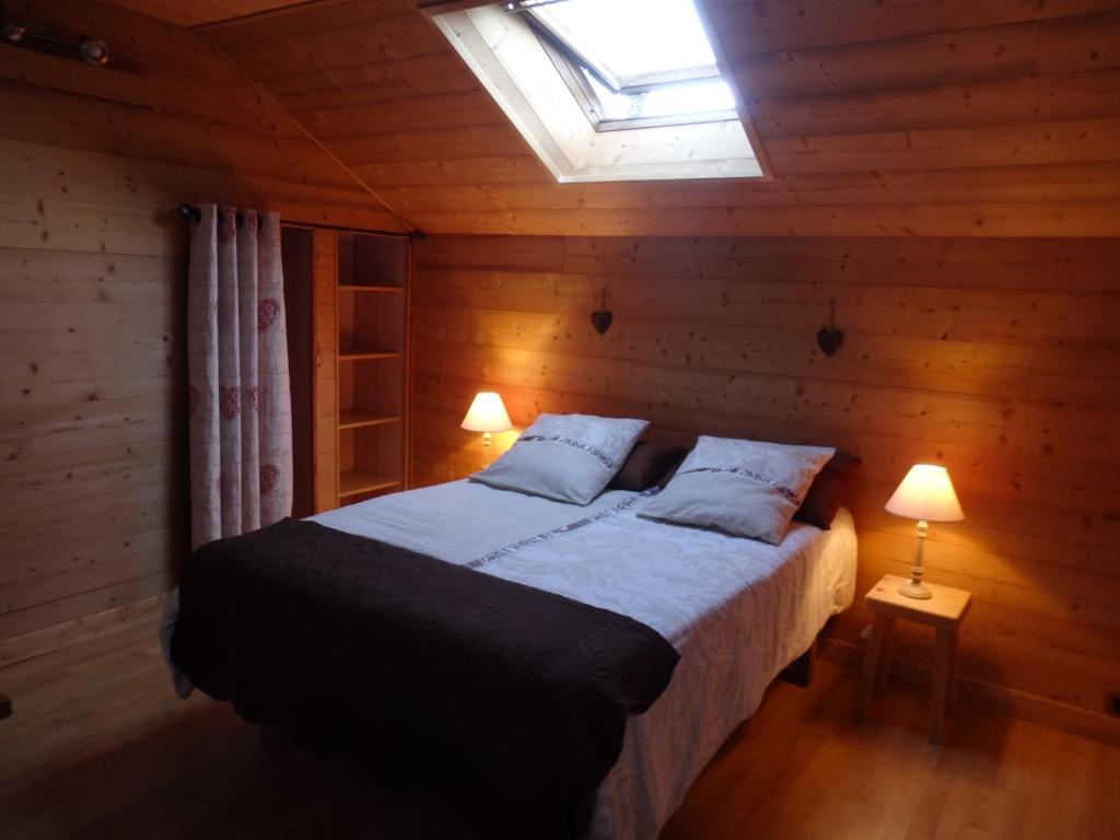 MarignierAU COEUR DES ALPES的木制客房内的一间卧室,配有一张床