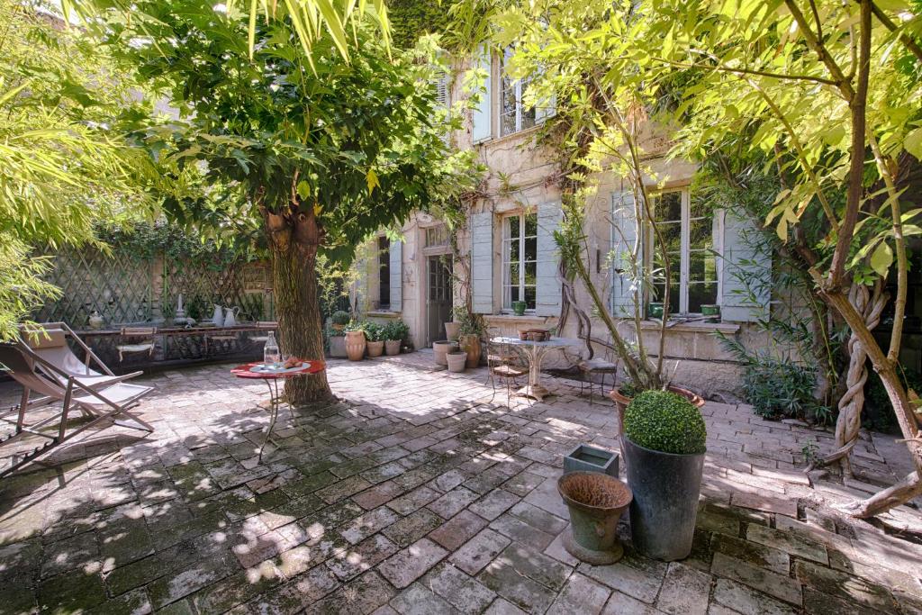 阿维尼翁茵特拉穆洛斯花园希谢度假屋的一座种有树木和长凳的庭院和一座建筑
